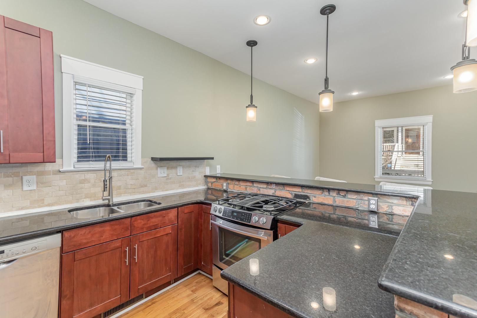 510 South Saunders Street Raleigh, NC 27603 - Photo 10 of 23 a kitchen with a stove a sink cabinets and a window
