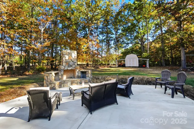 a view of a patio with table and chairs potted plants and a large tree