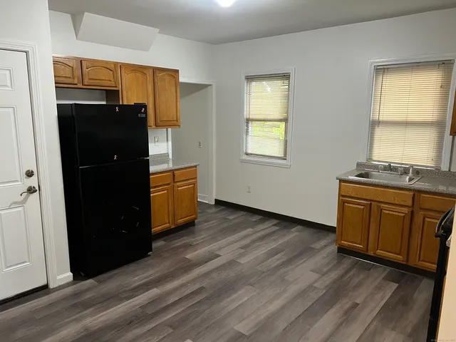 an empty room with wooden floor and window