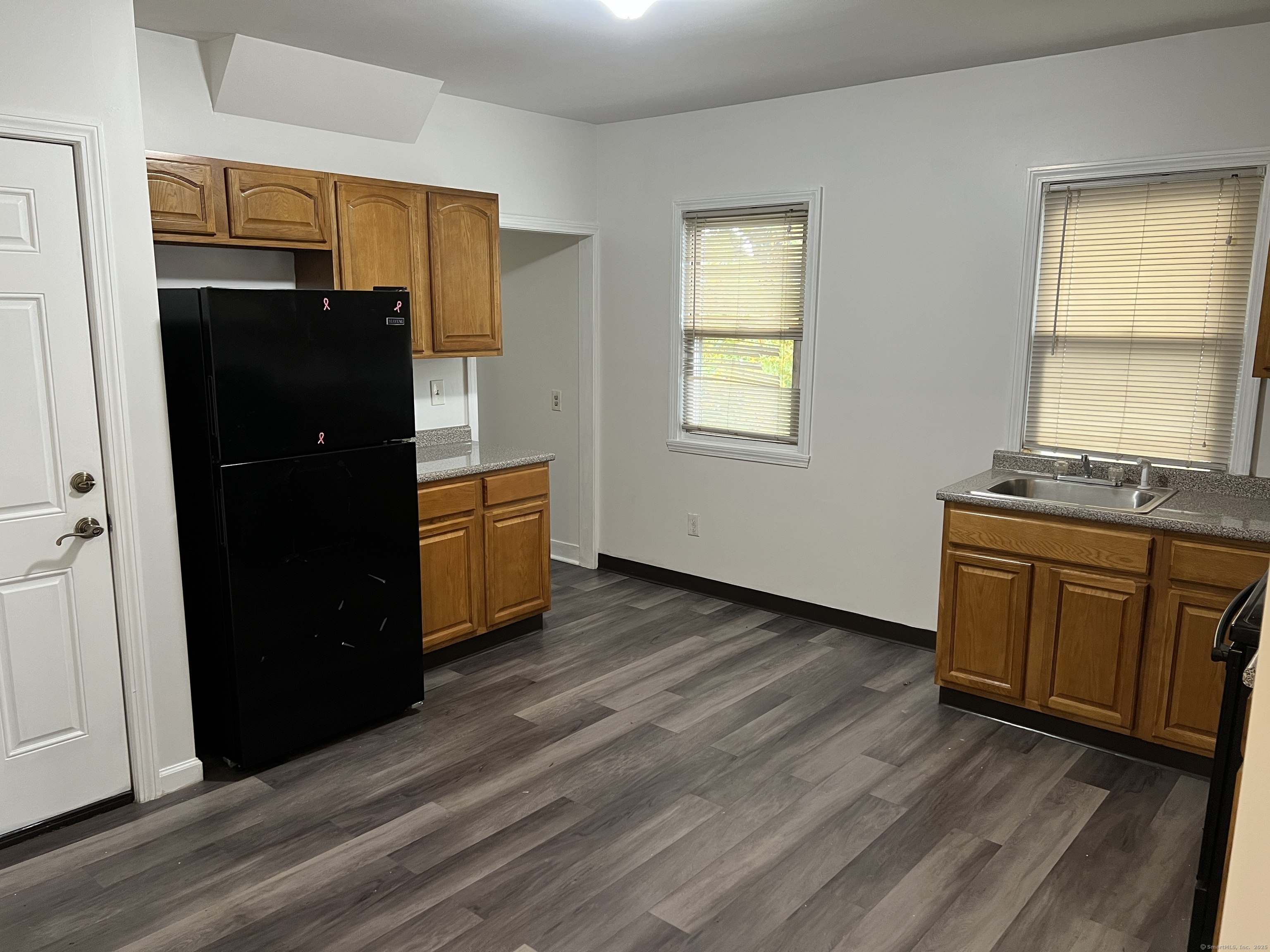 an empty room with wooden floor and window