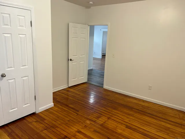 a view of an empty room with wooden floor