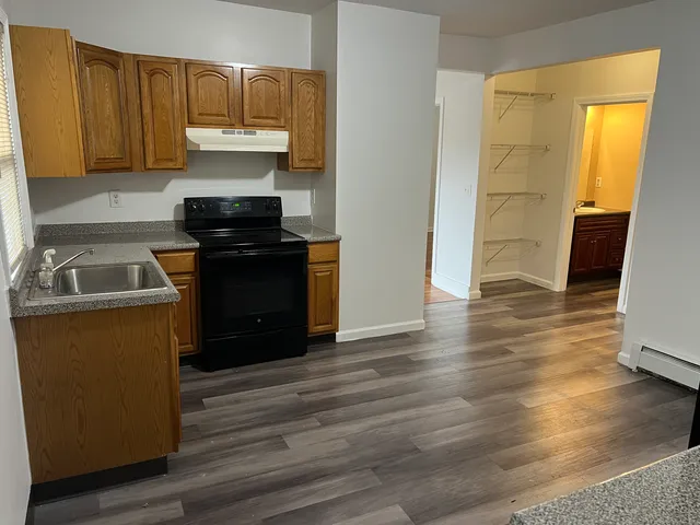 a kitchen with granite countertop wooden floors and stainless steel appliances