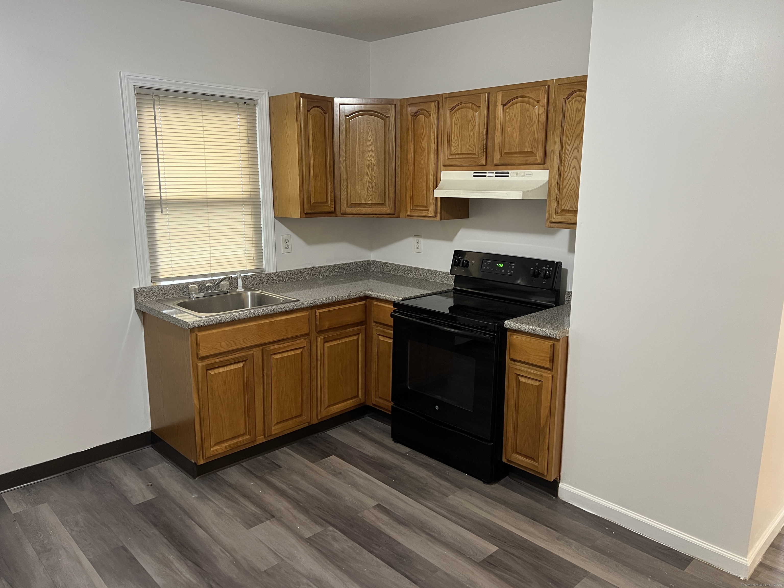 4 Magnolia Street, Unit 2 Hartford, CT 06112 - Photo 3 of 17 a kitchen with wooden floors and black appliances