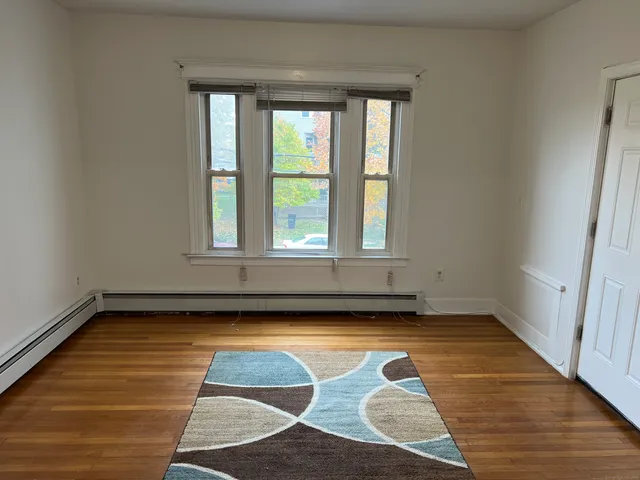 a view of a room with wooden floor and a window