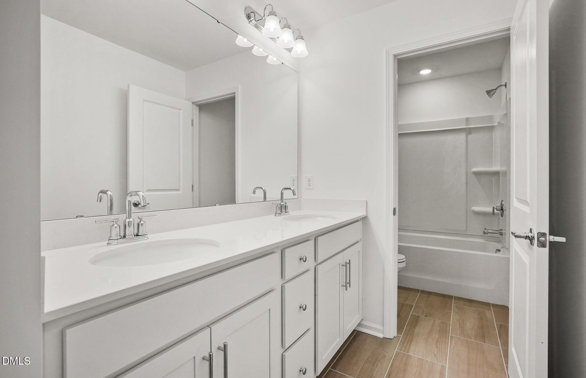 200 Armorial Court Willow Spring, NC 27592 - Photo 29 of 33 a bathroom with a double vanity sink a mirror and a bathtub