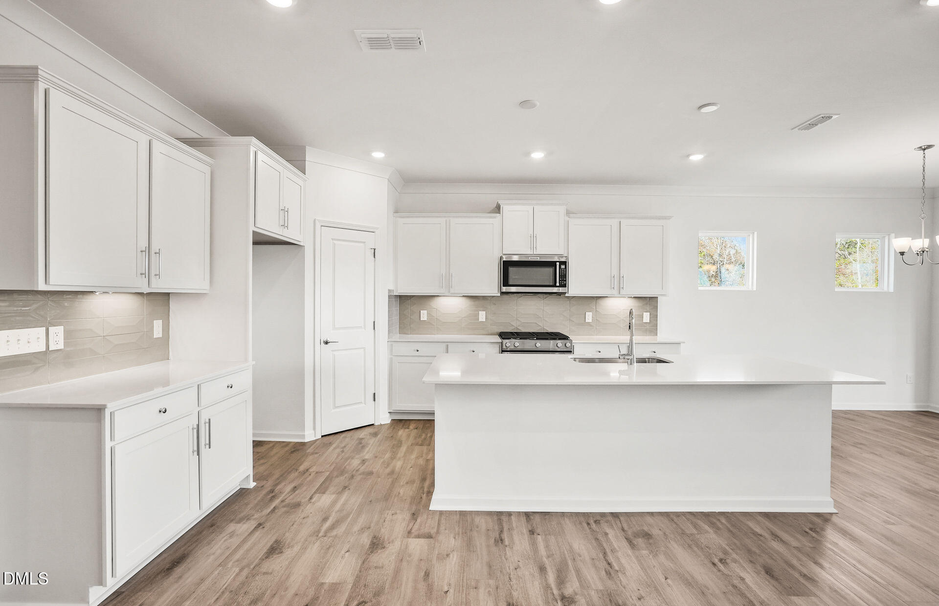200 Armorial Court Willow Spring, NC 27592 - Photo 6 of 33 a large kitchen with stainless steel appliances a sink a stove a refrigerator and white cabinets with wooden floor