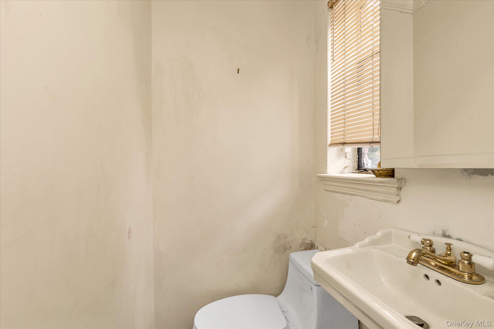 47-44 Glenwood Street Queens, NY 11362 - Photo 12 of 23 a bathroom with a sink and a toilet