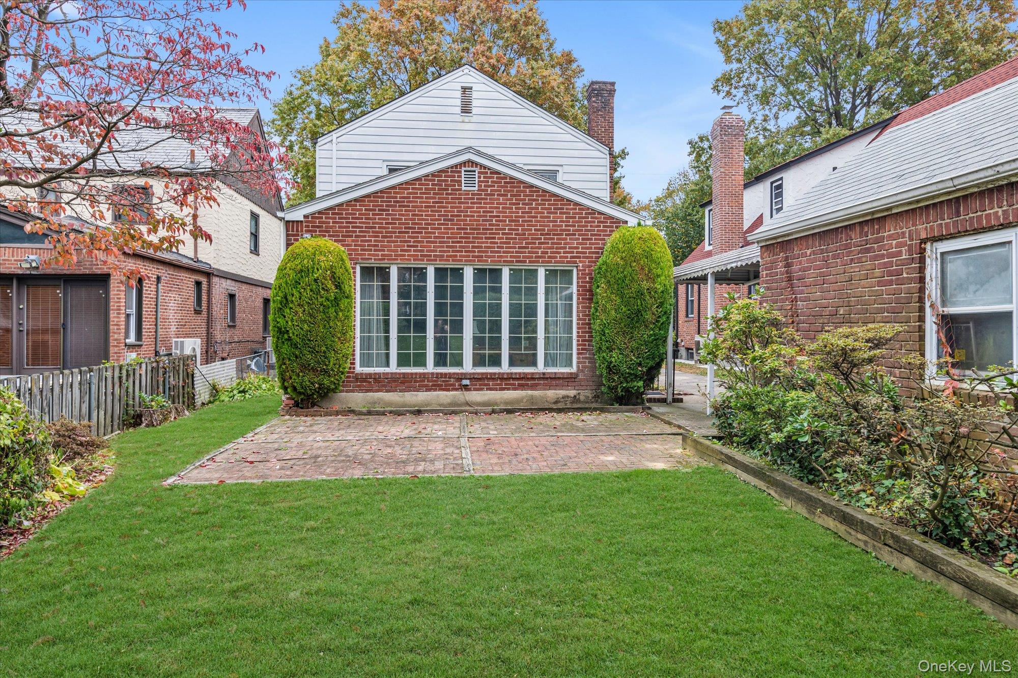47-44 Glenwood Street Queens, NY 11362 - Photo 21 of 23 a view of brick house with a yard plants and a large tree