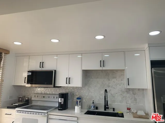 a kitchen with stainless steel appliances a stove a sink and a microwave