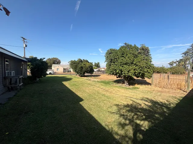 a view of a yard with yellow house