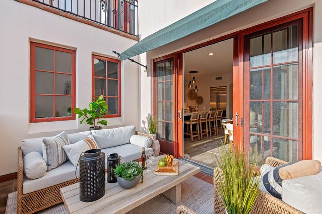 a view of a patio with couches table and chairs and potted plants