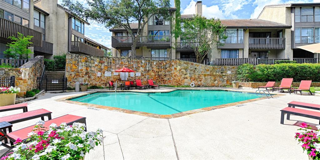 4561 North O'Connor Road, Unit 1292 Irving, TX 75062 - Photo 10 of 10 Inviting swimming pool with concrete decking, surrounded by natural stone retaining walls and lush landscaping