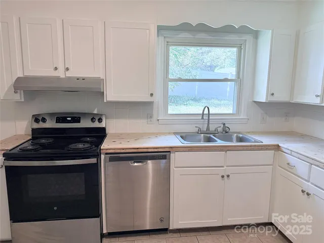 a kitchen with cabinets appliances and a window