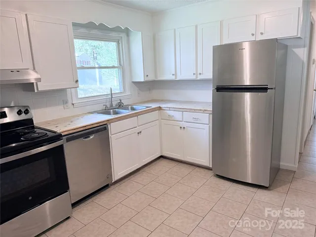 a kitchen with a refrigerator sink and cabinets