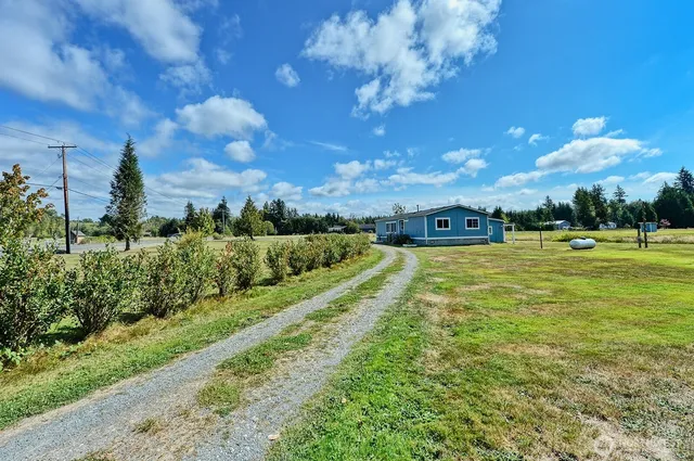 a view of a fountain in front of a house with a big yard