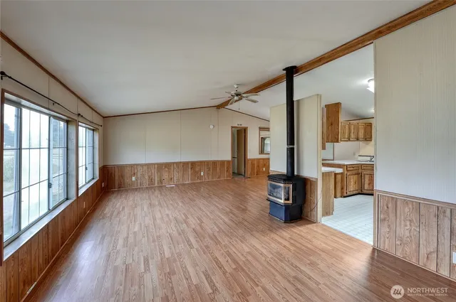 a view of a big room with wooden floor and windows