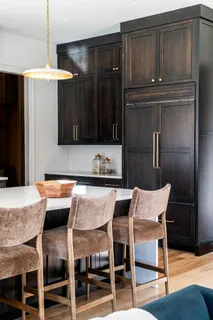 a kitchen with a table chairs refrigerator and cabinets