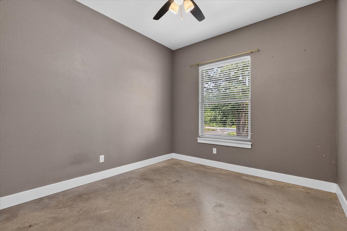 145 Cardinal Loop Paige, TX 78659 - Photo 29 of 40 A well-lit bedroom with a ceiling fan, ready for personal touches and offering a pleasant outdoor view.