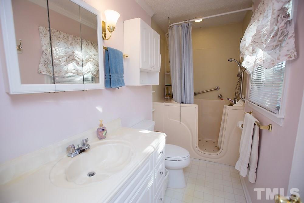 5602 McCormick Road Durham, NC 27713 - Photo 13 of 19 a bathroom with a sink a toilet and a mirror