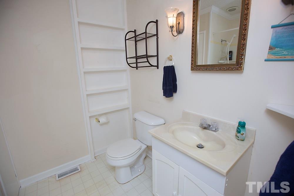 5602 McCormick Road Durham, NC 27713 - Photo 9 of 19 a bathroom with a toilet sink and mirror