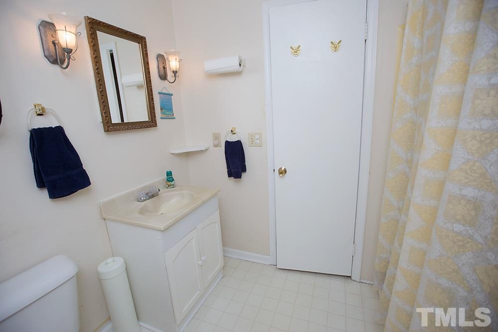 5602 McCormick Road Durham, NC 27713 - Photo 10 of 19 a bathroom with a sink a toilet and mirror