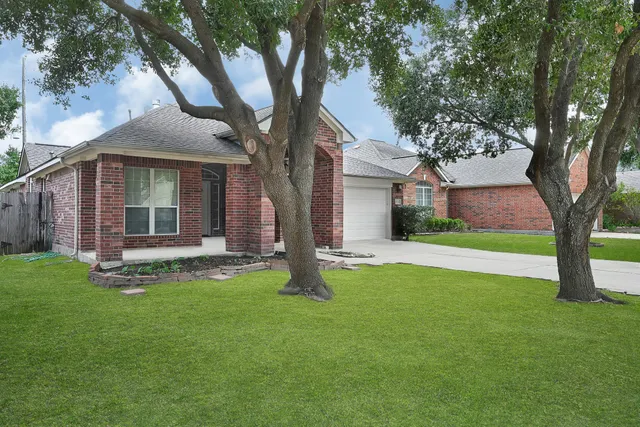 a view of a house with a yard and tree