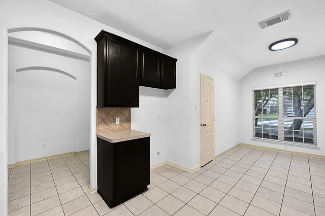 a view of an empty room with window and cabinet