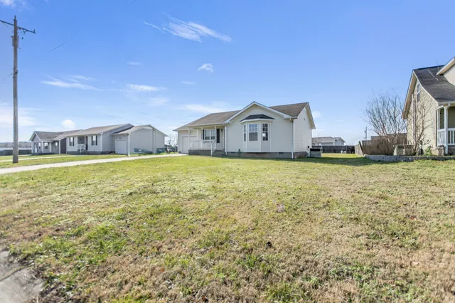 a view of a house with a big yard and potted plants