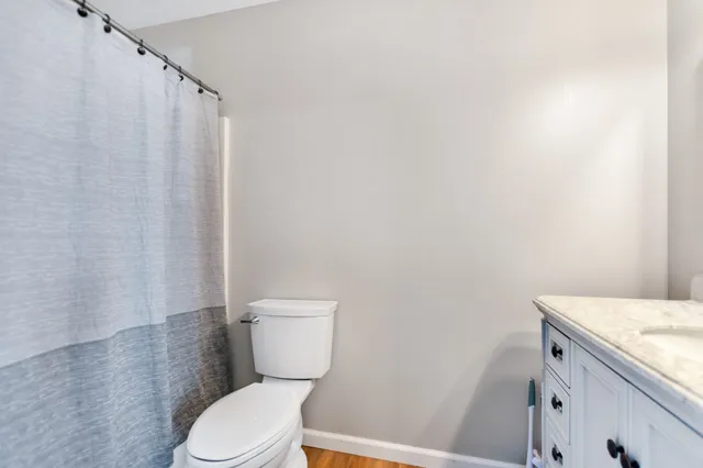 a white toilet sitting next to a shower curtain