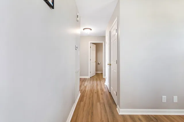a view of a hallway with wooden floor