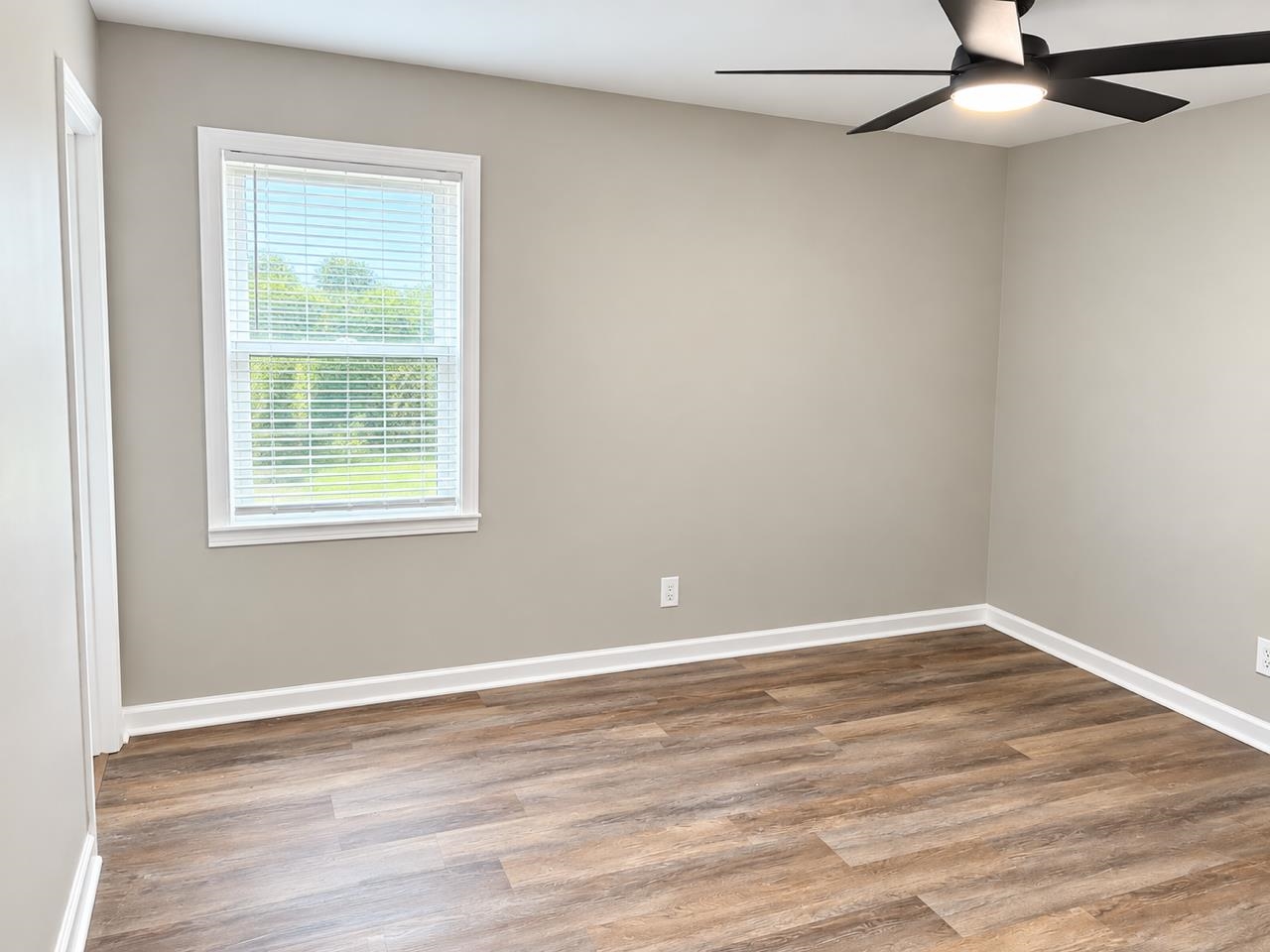 5085 Bowie Road Memphis, TN 38109 - Photo 8 of 8 Wood-finish flooring, neutral wall paint, white trim, and a modern ceiling fan with integrated lighting