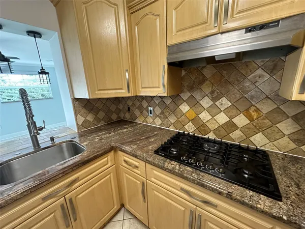 a kitchen with a sink a stove and cabinets