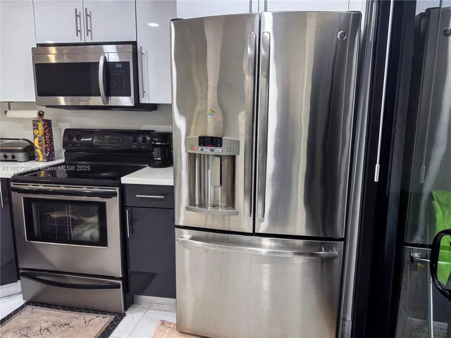 a metallic refrigerator freezer sitting in a kitchen