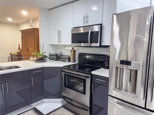 a kitchen with stainless steel appliances a stove a microwave and a sink