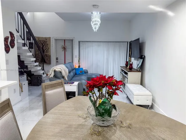 a living room with furniture flowerpot and a chandelier
