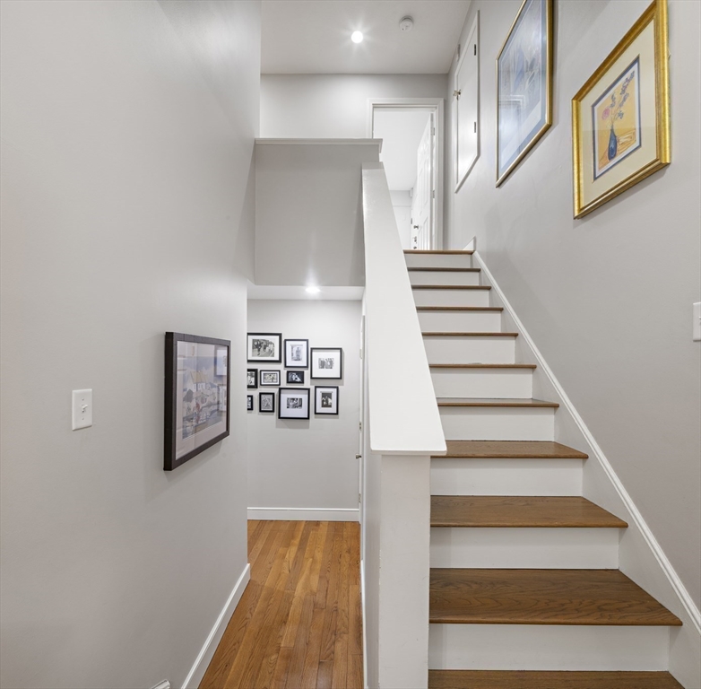 9 Appleton Street, Unit 304 Boston, MA 02116 - Photo 14 of 18 a view of staircase with wooden floor and lots of frames on wall