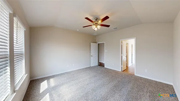 a view of a room with a ceiling fan and a window
