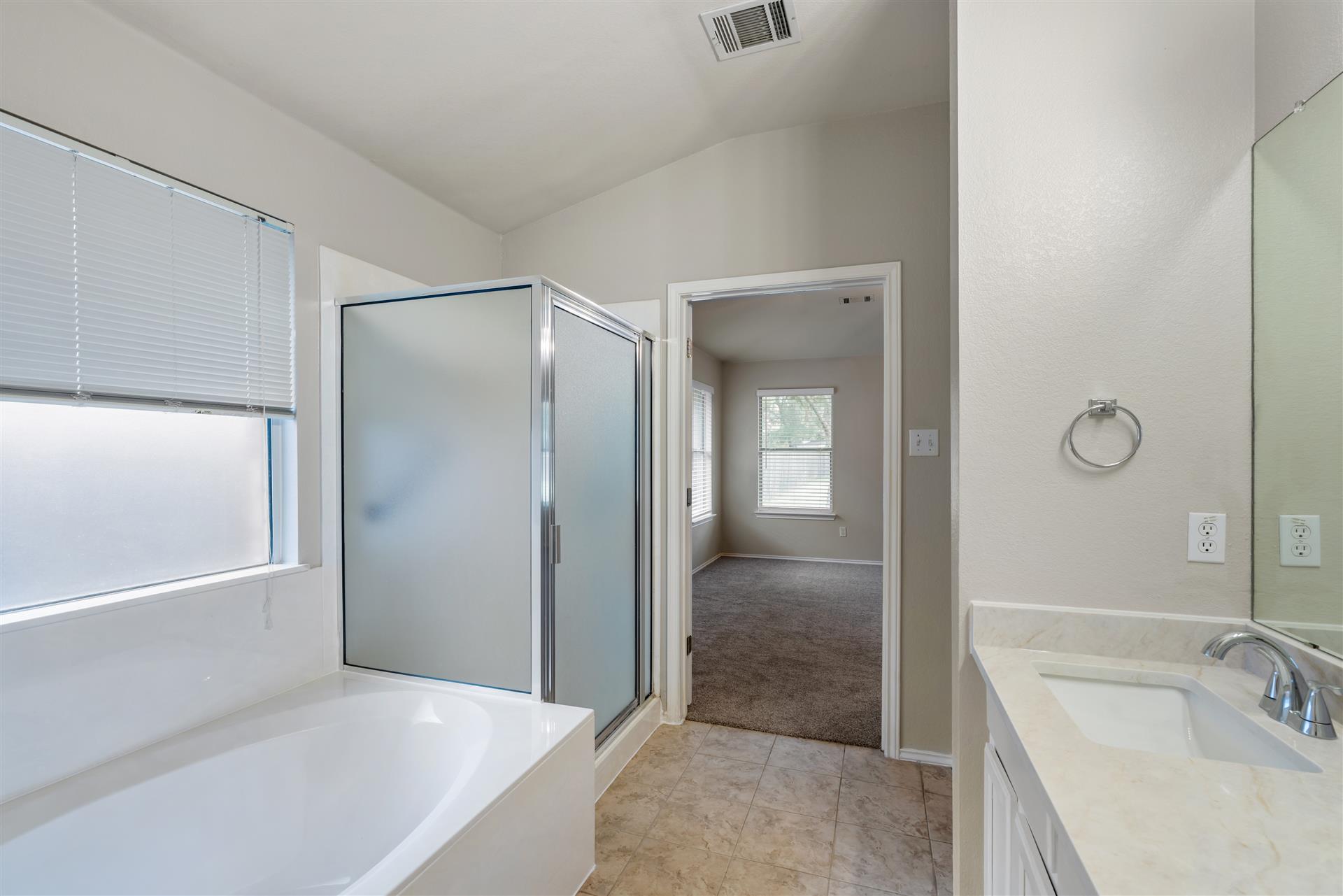 4725 Tello Path Austin, TX 78749 - Photo 21 of 34 A well-appointed bath boasts a shower and separate tub, complemented by a convenient vanity and tiled flooring.