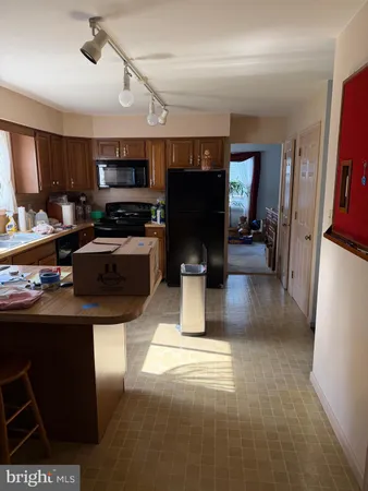 a kitchen with stainless steel appliances kitchen island granite countertop a refrigerator and a stove top oven