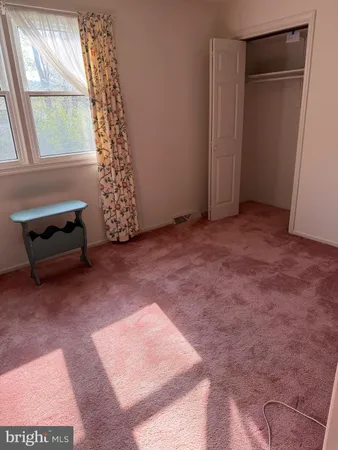 a view of an empty room with a fireplace and a window