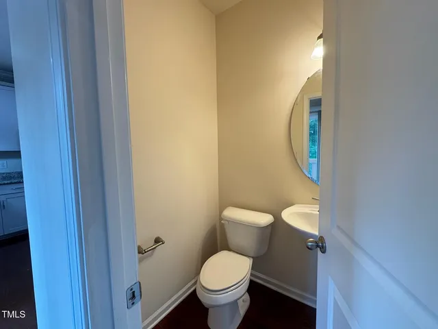 a white toilet sitting next to a bathroom sink and a vanity