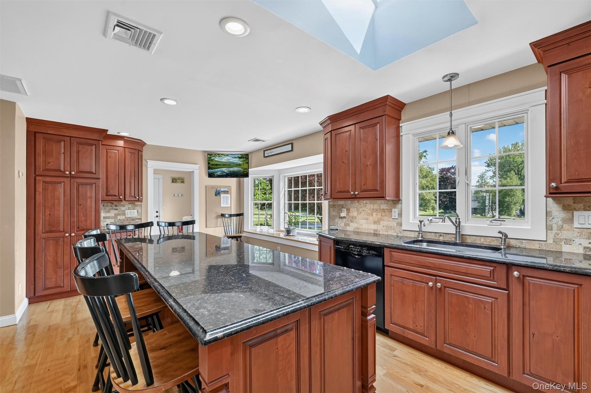 5 Hedges Road Warwick, NY 10990 - Photo 10 of 48 The updated chef’s kitchen is bright and inviting, with granite countertops, rich wood cabinetry, a skylight above, and a large island with seating for six.