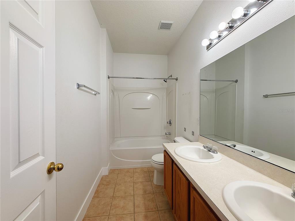 194 Sand Ridge Drive Davenport, FL 33896 - Photo 12 of 17 a bathroom with a sink double vanity and a mirror