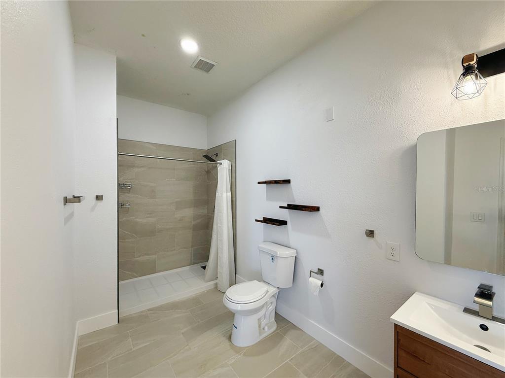 194 Sand Ridge Drive Davenport, FL 33896 - Photo 2 of 17 a bathroom with a toilet a sink and shower