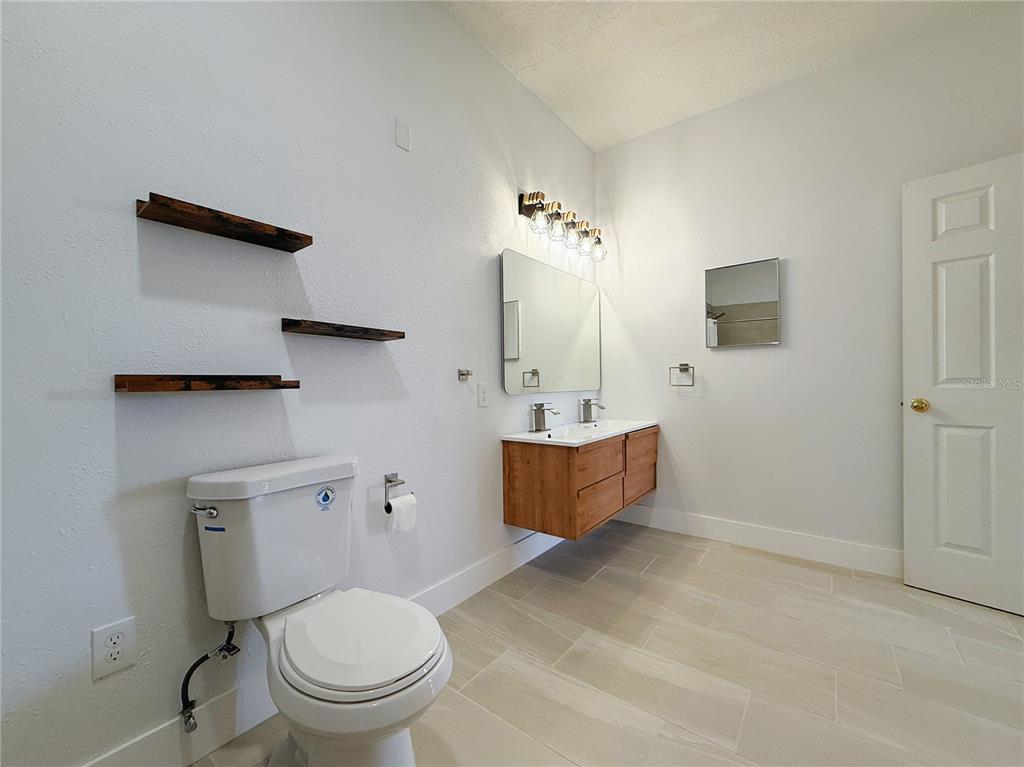 194 Sand Ridge Drive Davenport, FL 33896 - Photo 3 of 17 a bathroom with a toilet a sink and mirror