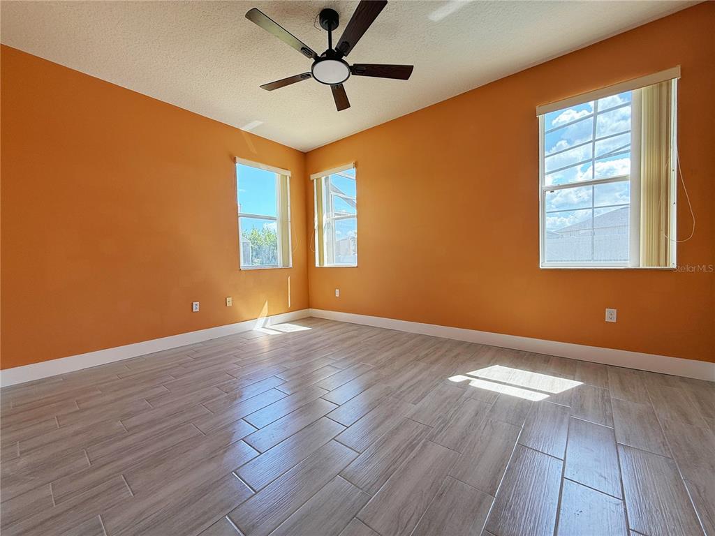 194 Sand Ridge Drive Davenport, FL 33896 - Photo 4 of 17 a view of an empty room with wooden floor and a window