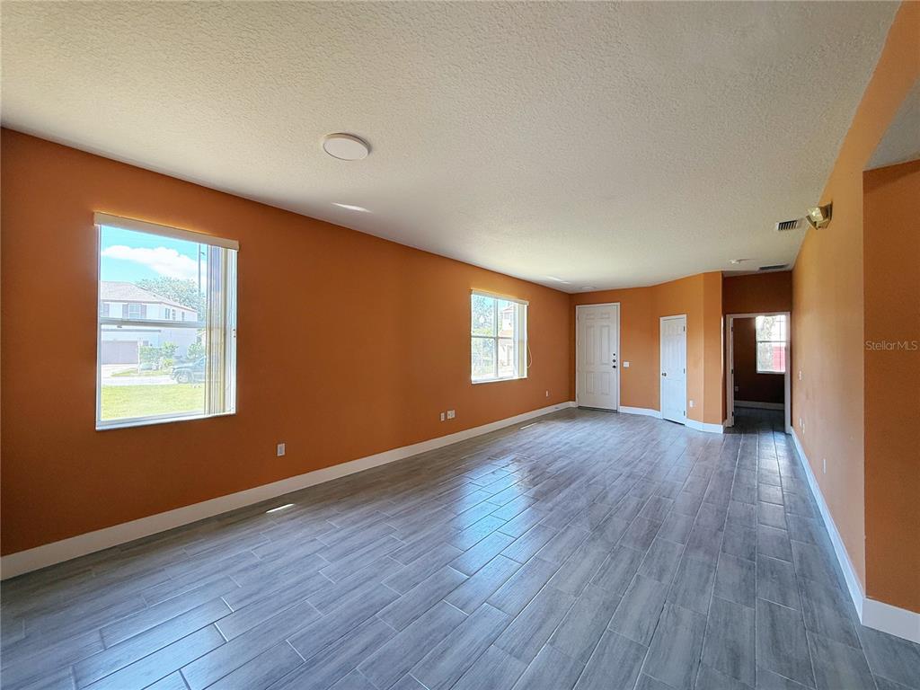 194 Sand Ridge Drive Davenport, FL 33896 - Photo 9 of 17 a view of an empty room with wooden floor and a window