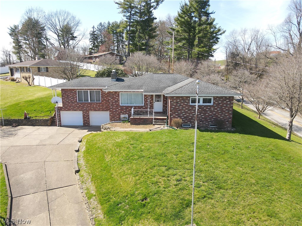Single story home featuring a front yard and a garage