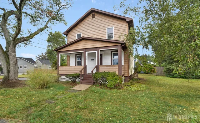 a view of a yard in front of a house with large trees