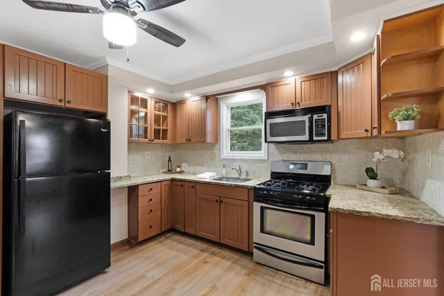 a kitchen with stainless steel appliances granite countertop a stove a sink dishwasher a refrigerator and a microwave